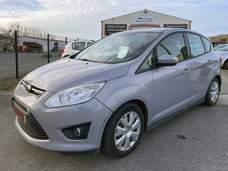 Salon automobile intérieur avec visiteur observant véhicule exposé